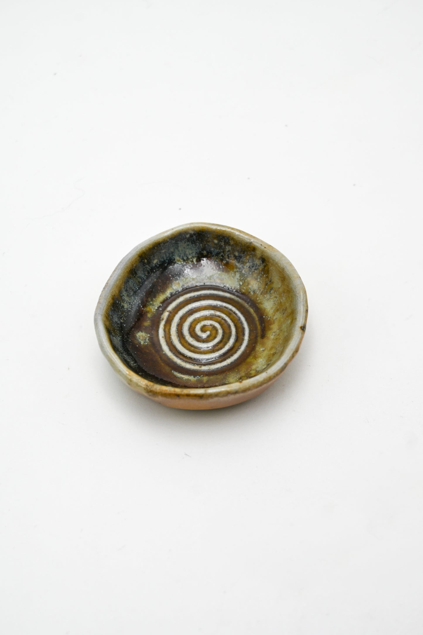 Small ceramic dish with a spiral design on a white background